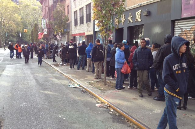 Residents line up to have their phones charged at CAAAV at 10 a.m.